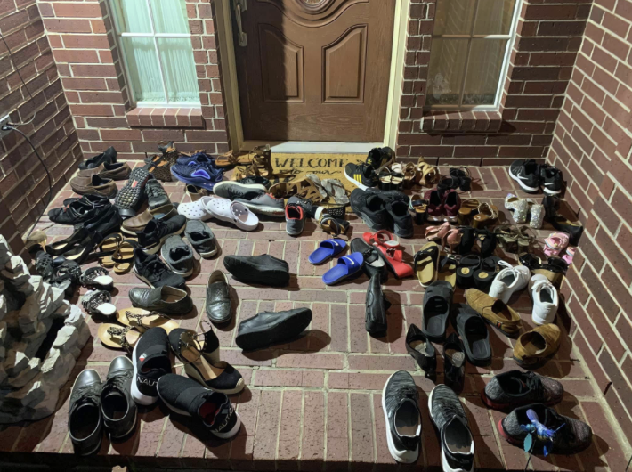 Pile of shoes removed at a doorway