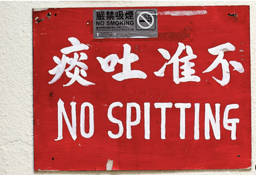 Red NO SPITTING sign in Chinese and English